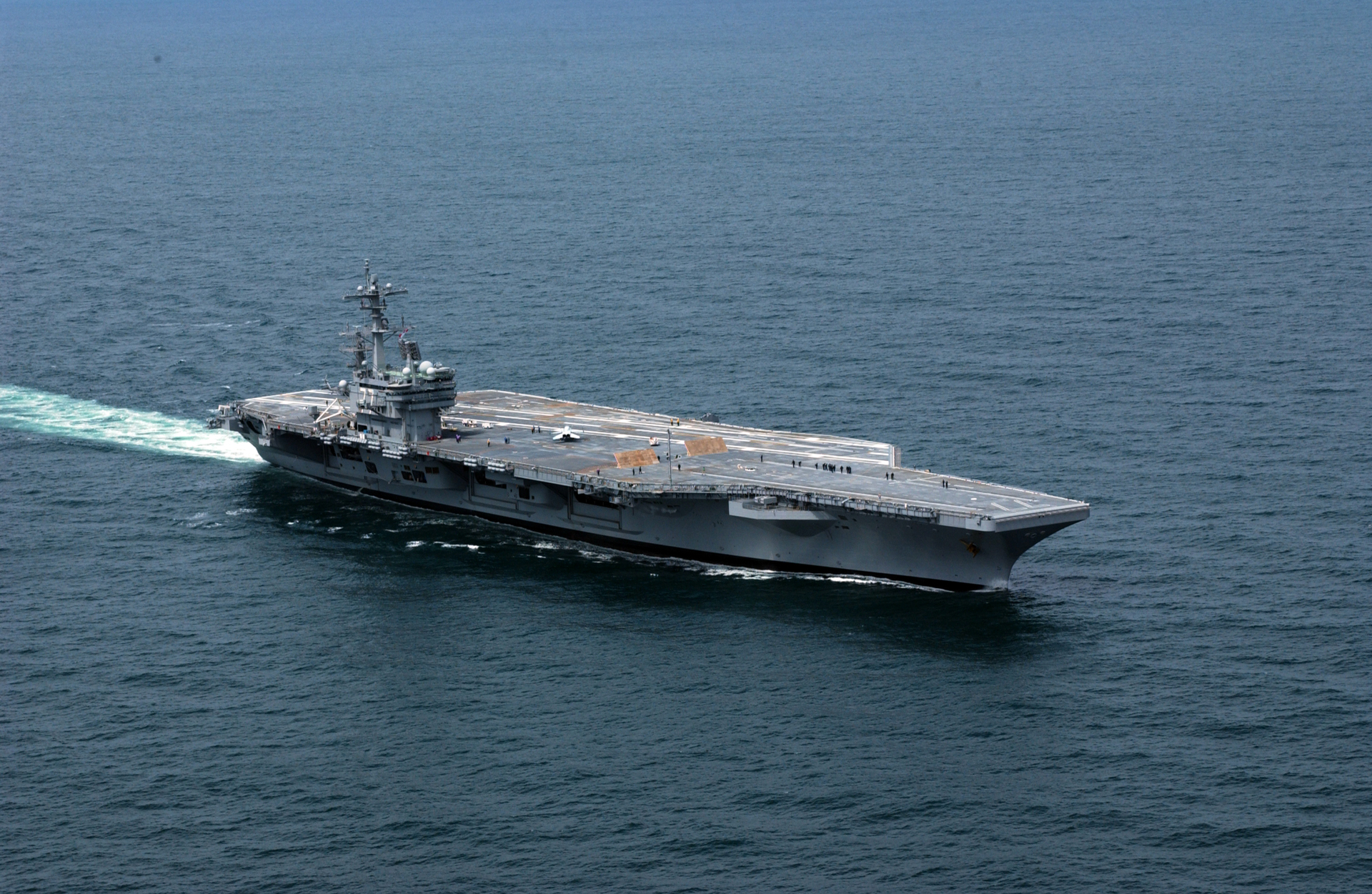 USS George H.W. Bush (CVN-77) underway at sea, aerial view showing the carrier’s flight deck and wake, deployed from Norfolk March 31 2026 as part of Carrier Strike Group 10
