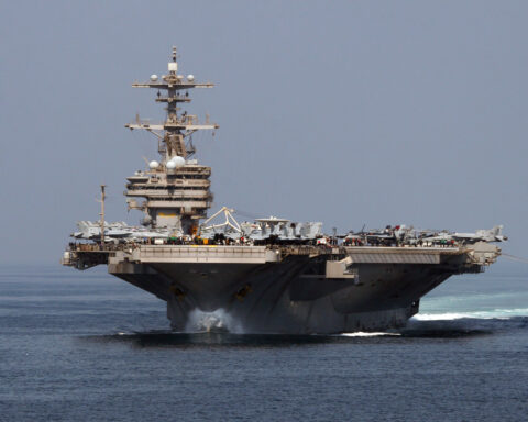 USS George H.W. Bush (CVN-77) transiting the Strait of Hormuz — the same carrier that in 2026 was forced to sail 6,000 miles around Africa because Iran mined the strait shut.