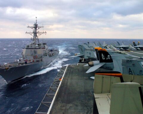 USS Mason (DDG-87), an Arleigh Burke-class guided-missile destroyer, makes way in the Atlantic alongside USS Dwight D. Eisenhower. Mason is one of the destroyers assigned to enforce Operation Epic Fury maritime interdiction.