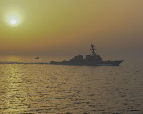 The guided-missile destroyer USS Stout (DDG 55) transits the Strait of Hormuz at sunset alongside USS Bataan, May 31, 2020. The United States and Iran now jointly blockade the strait from opposite ends — CENTCOM controls the Arabian Sea entry, the IRGC controls the Gulf of Oman exit. Photo: Cpl. Gary Jayne III / U.S. Marine Corps / Public Domain