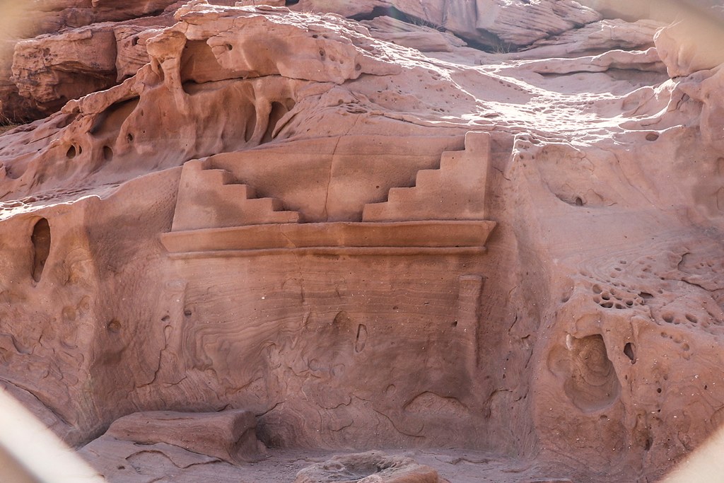 Nabataean rock-cut tomb facade carved into red sandstone cliffs at Wadi Disah, Tabuk Province