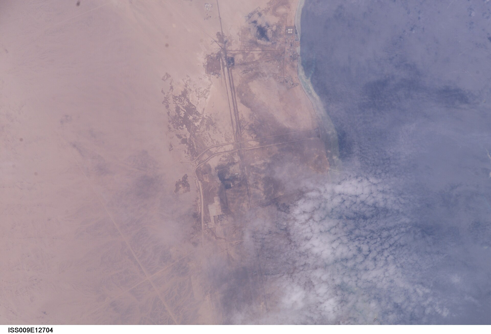 ISS astronaut photograph of Yanbu industrial city on Saudi Arabia's Red Sea coast — the fallback water supply for western Saudi Arabia, already running at full capacity with no surplus pipeline capacity to redirect eastward to Riyadh