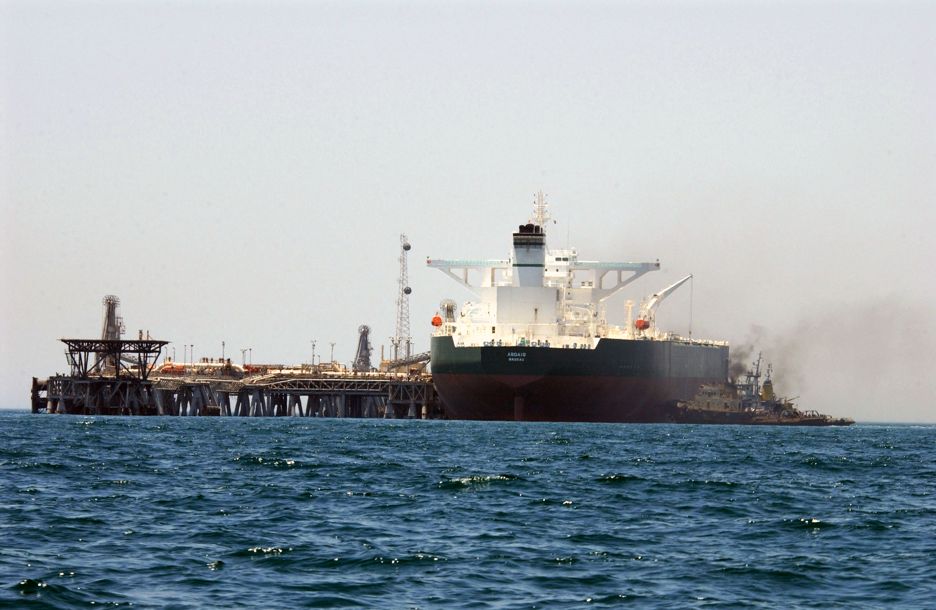 The Saudi Aramco supertanker AbQaiq manoeuvres into position at an offshore crude oil loading terminal in the Persian Gulf. Saudi Arabia exported roughly 7.76 million barrels per day in Q1 2026, far below the 10.291 mb/d OPEC+ quota, as the Hormuz closure forced all exports through the constrained East-West Pipeline to Yanbu. Photo: U.S. Navy / Public domain