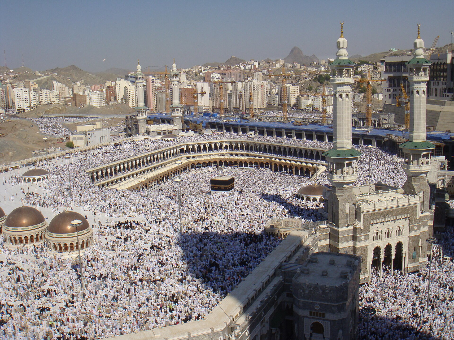 Aerial view of Masjid al-Haram in Mecca during Hajj, showing hundreds of thousands of white-clad pilgrims circling the Kaaba — the pilgrimage Saudi Arabia must protect as negotiations proceed