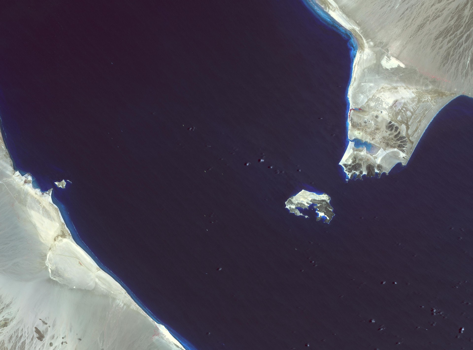 NASA ASTER satellite image of Bab el-Mandeb strait showing the 29-kilometre passage between Yemen and Djibouti, with Perim Island visible in the centre — the western chokepoint threatened by Houthi forces