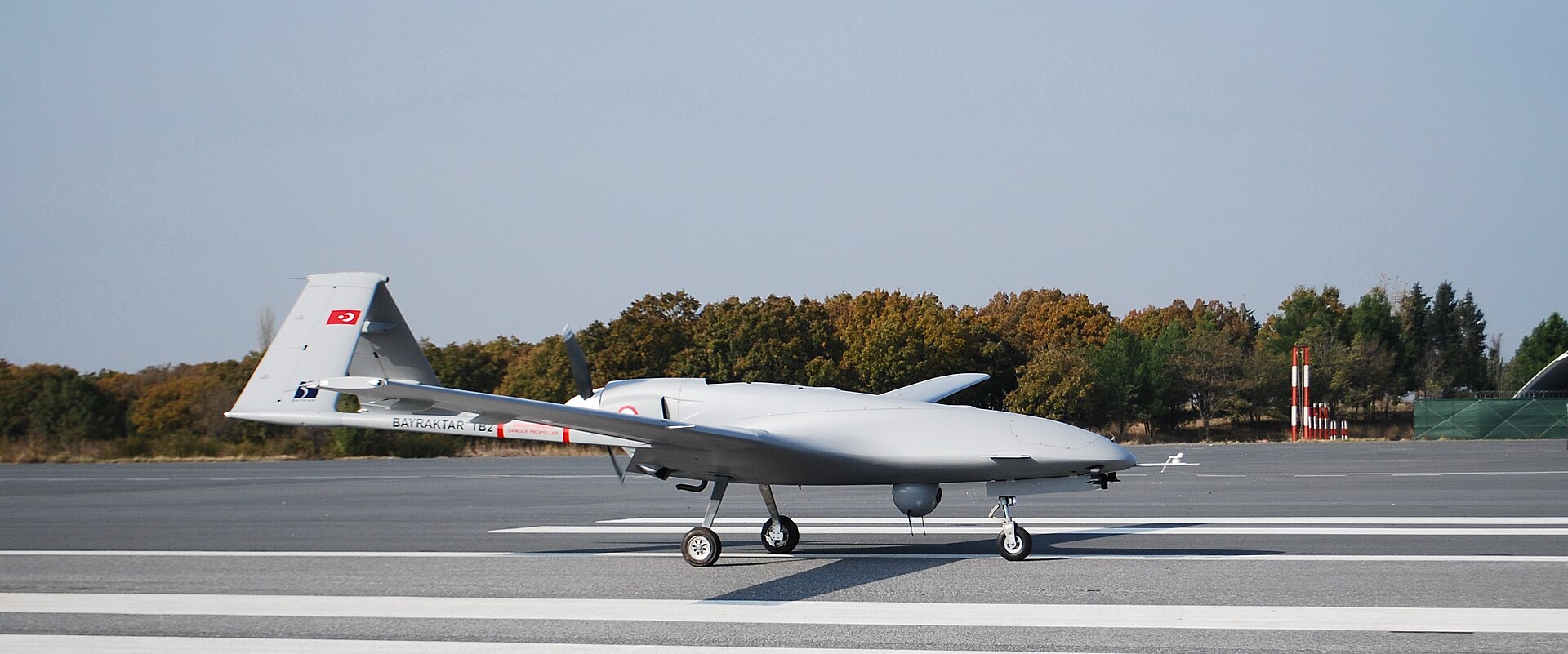 Turkish Bayraktar TB2 UCAV on the runway, showing the Turkish flag on the tail fin — Baykar has delivered TB2 drones to Qatar, UAE and Kuwait, with 60 Akinci UCAVs on order for Saudi Arabia under a joint production agreement with SAMI