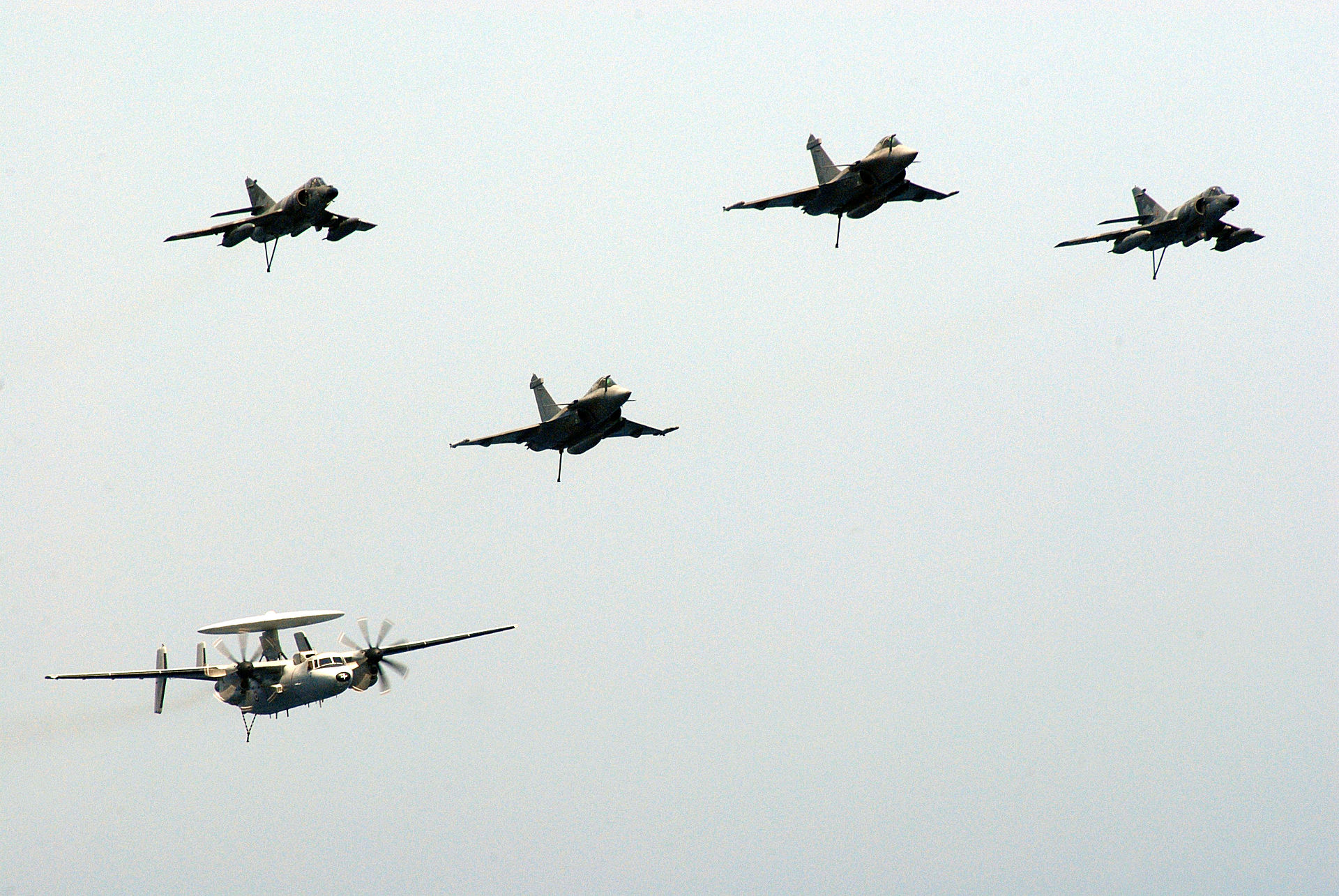 Four Rafale fighter jets and an E-2C Hawkeye airborne early warning aircraft from the Charles de Gaulle carrier air wing in formation flight