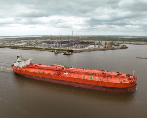 Crude oil tanker Eagle Kinabalu passes a new LNG terminal at Port Arthur, Texas — aerial view of a laden tanker in a shipping channel