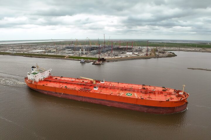 Crude oil tanker Eagle Kinabalu passes a new LNG terminal at Port Arthur, Texas — aerial view of a laden tanker in a shipping channel