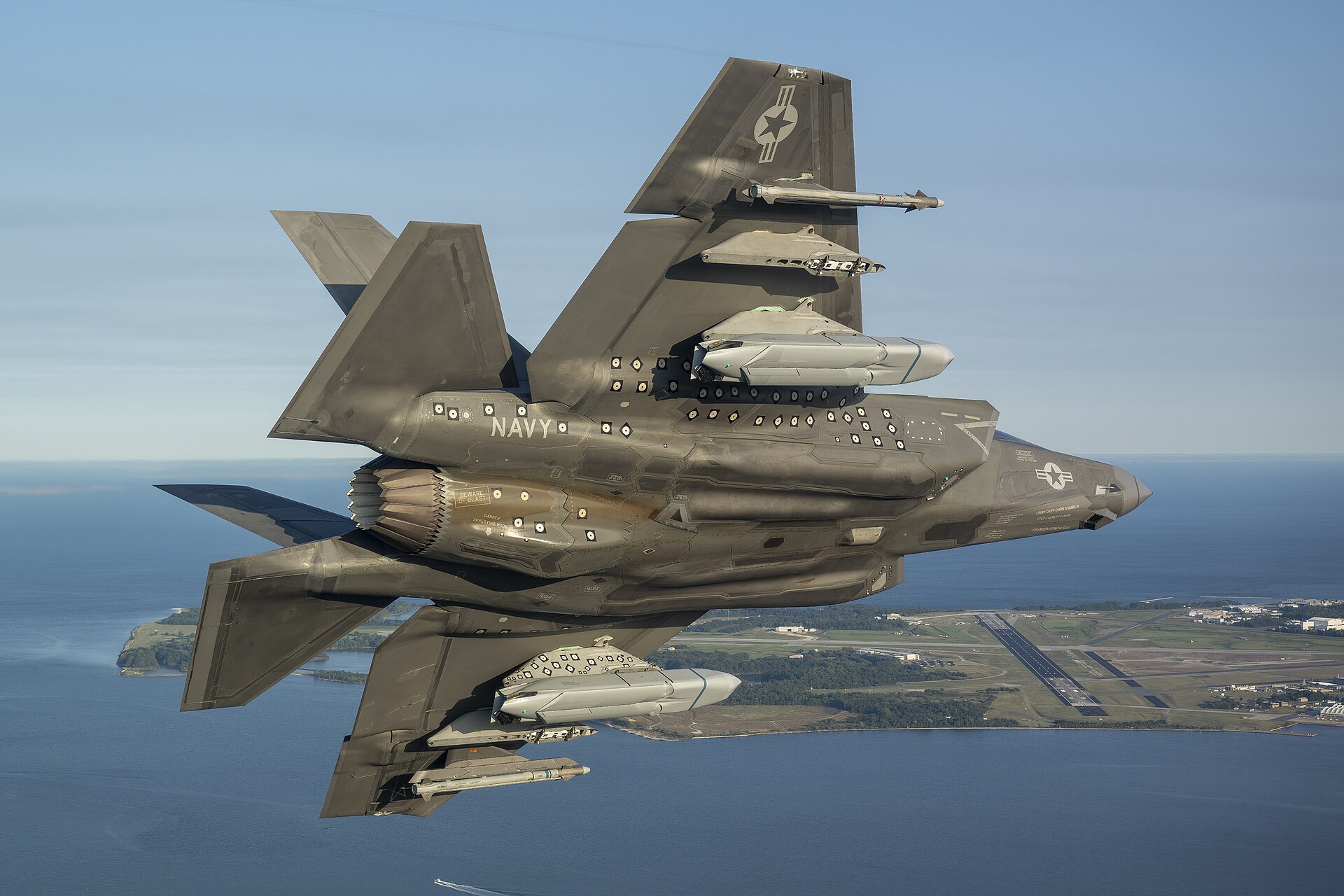 F-35C Navy fighter jet armed with AGM-158C LRASM missiles at NAS Patuxent River — the JASSM family, powered by Williams International engines built at a single Pontiac, Michigan facility, represents the binding constraint on any resumed US air campaign against Iran