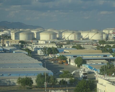 Oil storage tanks at Fujairah Oil Industry Zone, UAE, with Fujairah Free Zone entrance visible in foreground