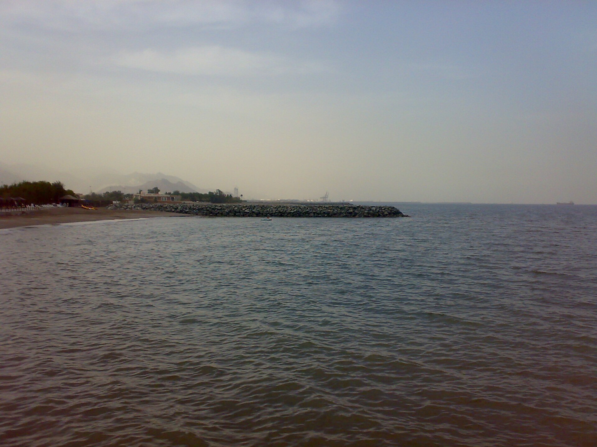 Fujairah port on the Gulf of Oman coast, with the transit oil terminal in the distance — the UAE bypass crude export facility struck by Iranian drones on May 4, 2026, the same day as Project Freedom.