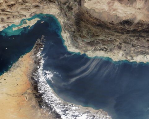 NASA MODIS satellite image of the Gulf of Oman and Strait of Hormuz, showing the UAE and Oman coastlines with dust plumes over the water — the area where IRGC forces seized a vessel 38 nautical miles northeast of Fujairah on May 14, 2026