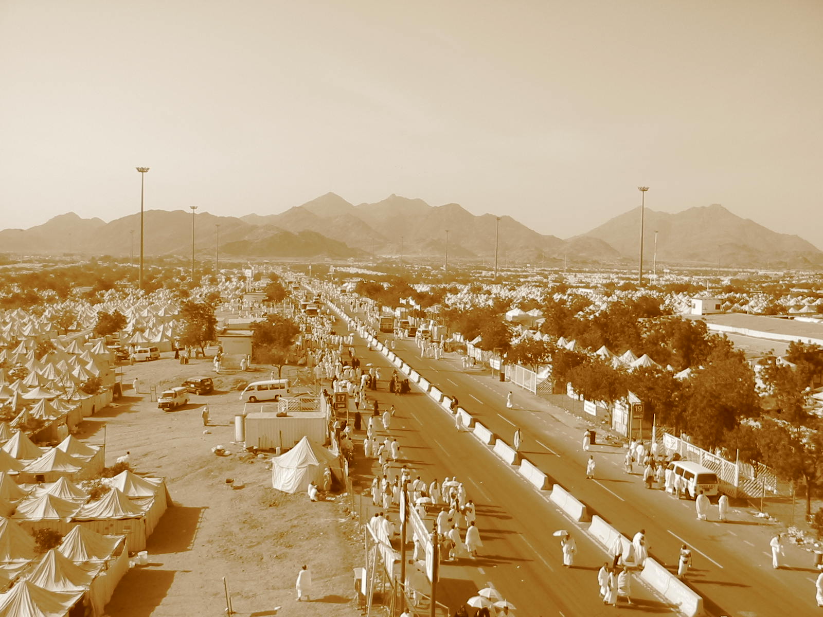 Hajj pilgrims on the Plain of Arafat, white tents stretching to the mountains — the Day of Arafah gathers 1.8 million worshippers annually