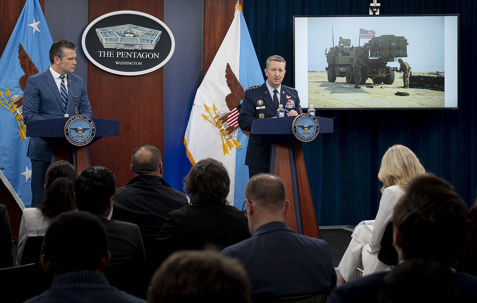 Defense Secretary Pete Hegseth and Gen. Dan Caine, Chairman of the Joint Chiefs of Staff, at Pentagon briefing podiums during Operation Epic Fury press conference, April 8, 2026