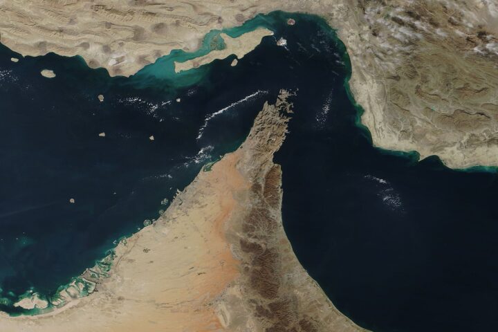Satellite view of the Strait of Hormuz and Musandam Peninsula showing the 21-mile chokepoint between Iran and Oman. The strait handles approximately 20% of global seaborne oil trade. NASA MODIS / Public Domain