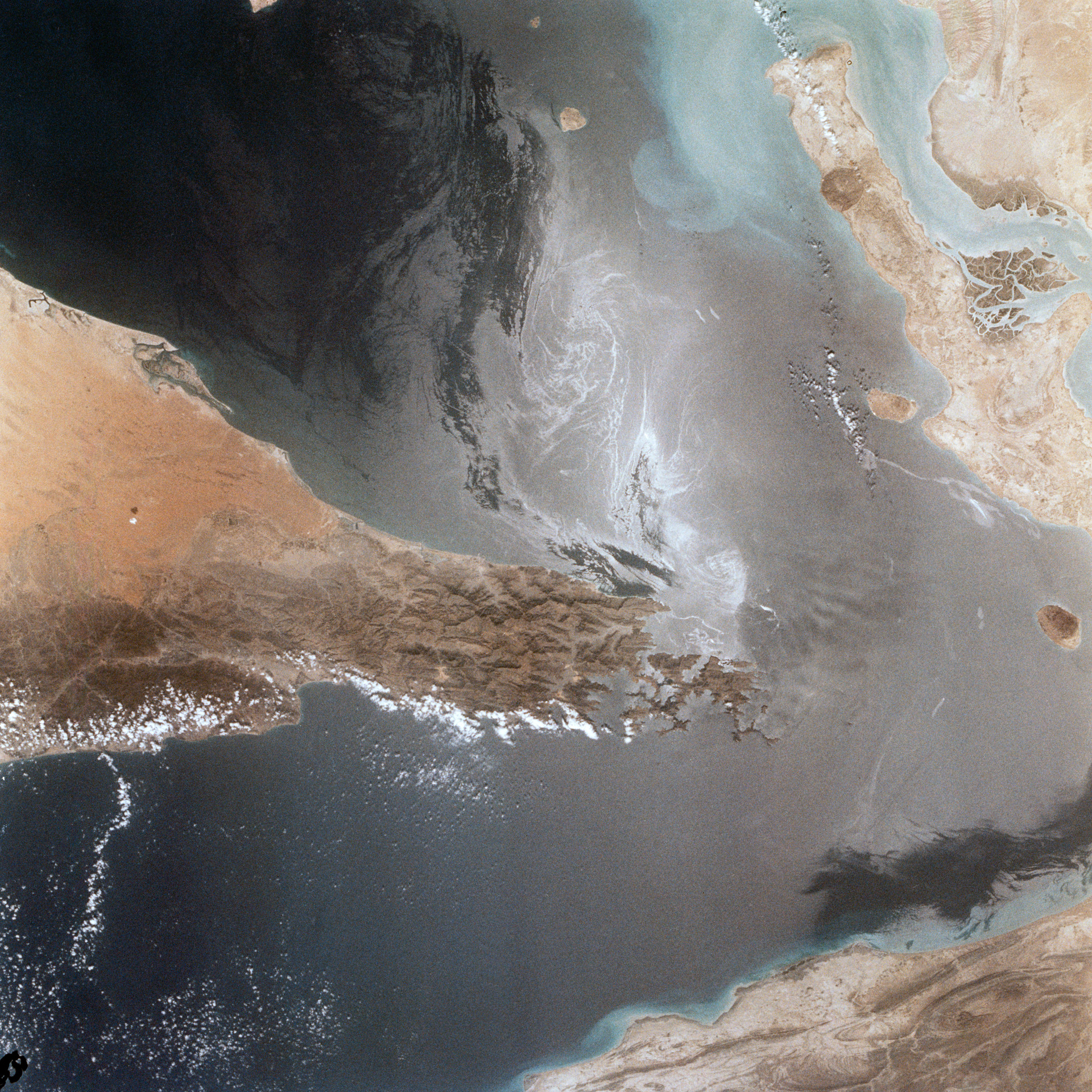 Strait of Hormuz photographed from Space Shuttle orbit in 1982, showing the narrow chokepoint between Iran and the Musandam Peninsula of Oman through which 20 percent of global oil trade passes. Photo: NASA / Public Domain