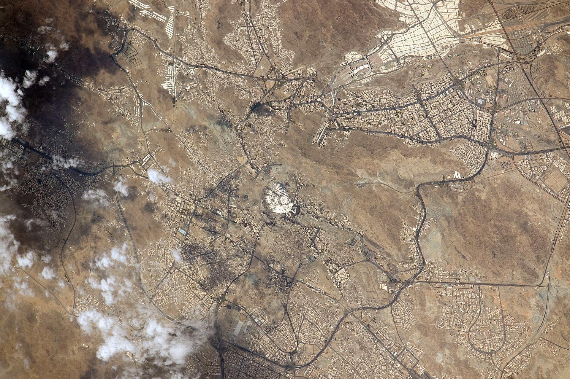 NASA ISS-44 orbital photograph of Mecca, Saudi Arabia, showing the Masjid al-Haram complex at center surrounded by the city and Hejaz mountain terrain