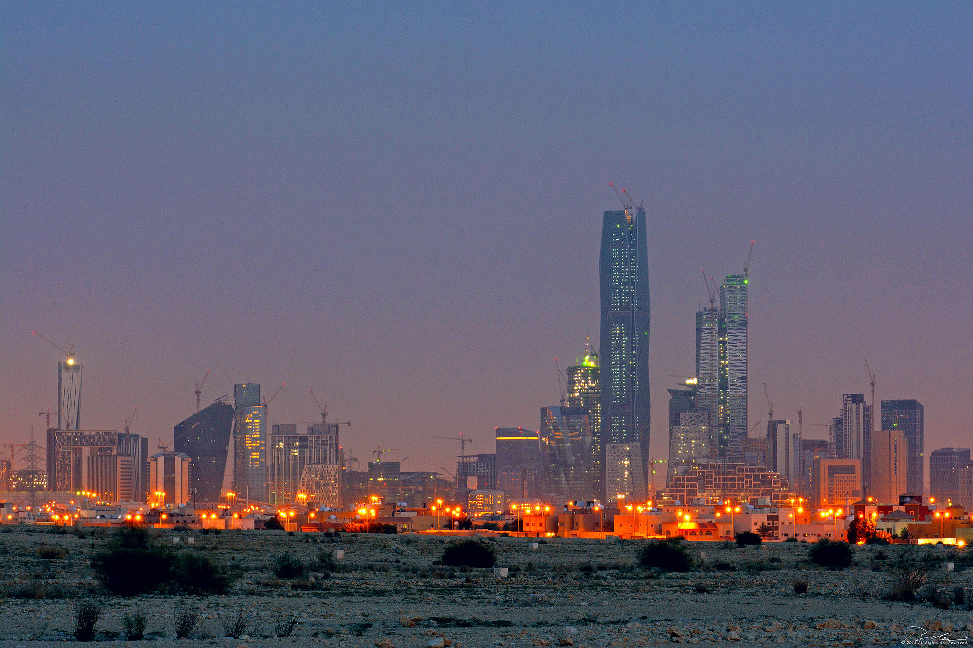 King Abdullah Financial District KAFD Riyadh seen from northeast at dusk with construction cranes and financial towers illuminated