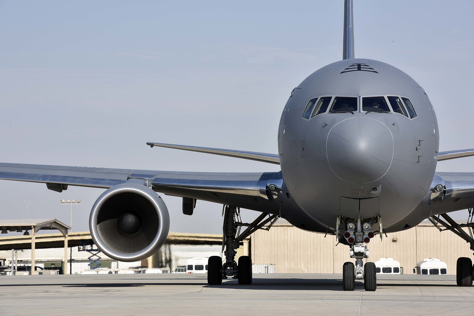 KC-46 Pegasus refueling tanker aircraft on the flightline at Al Udeid Air Base Qatar with desert base infrastructure visible behind