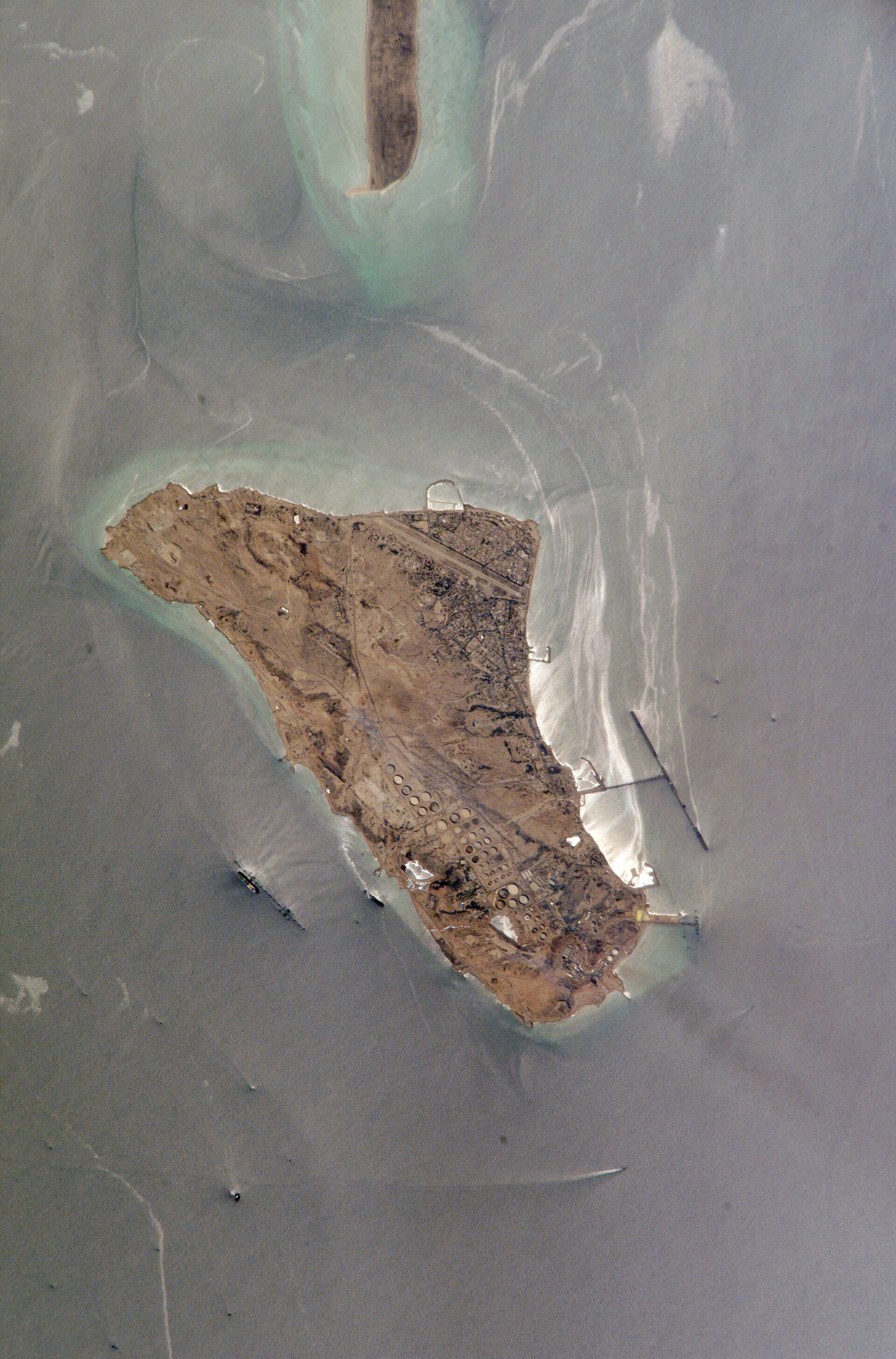Kharg Island photographed from the ISS, with VLCC tankers visible at loading jetties and oil sheen on the Persian Gulf surface