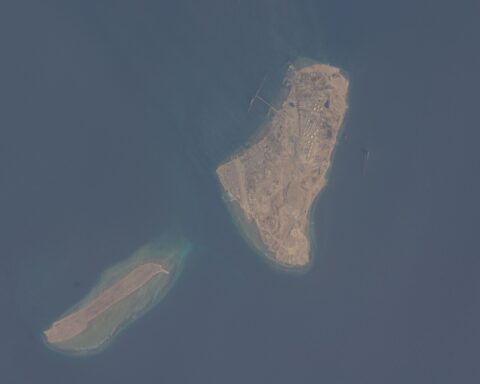Kharg Island oil terminal from the International Space Station, showing circular storage tanks and loading jetties in the Persian Gulf