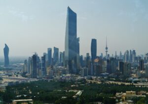 Kuwait City skyline showing the al-Hamra Tower and Kuwait Liberation Tower — the city has absorbed 265 ballistic missile intercepts since February 28 and filed a UN Charter Article 51 self-defense claim alone, without a single GCC partner