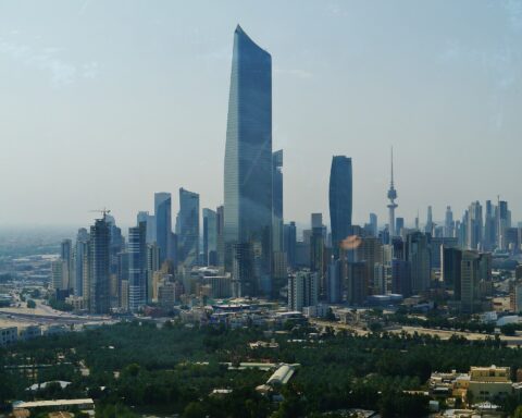 Kuwait City skyline showing the al-Hamra Tower and Kuwait Liberation Tower — the city has absorbed 265 ballistic missile intercepts since February 28 and filed a UN Charter Article 51 self-defense claim alone, without a single GCC partner