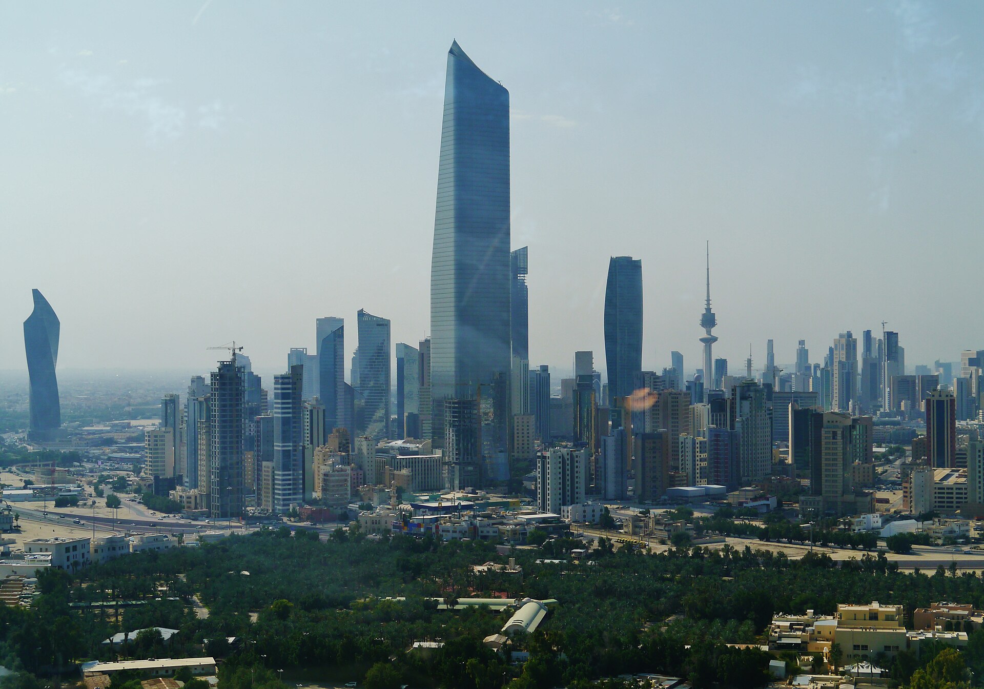 Kuwait City skyline showing the al-Hamra Tower and Kuwait Liberation Tower — the city has absorbed 265 ballistic missile intercepts since February 28 and filed a UN Charter Article 51 self-defense claim alone, without a single GCC partner