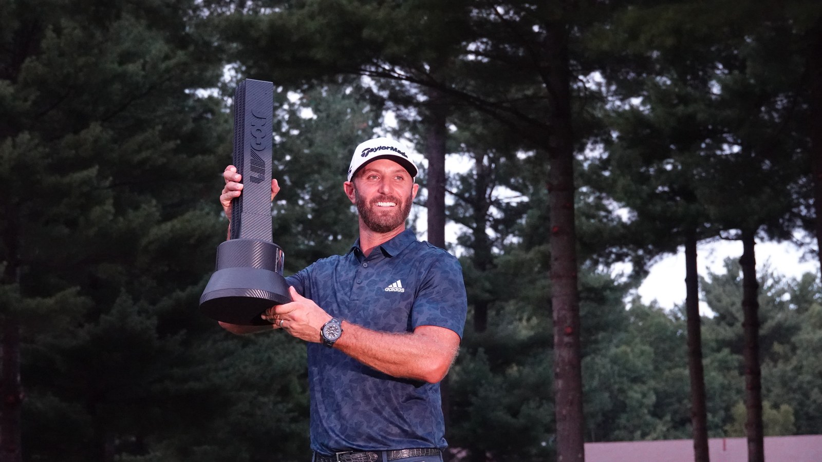 Dustin Johnson holds the LIV Golf Boston tournament trophy — LIV paid out over $255 million in player contracts in its first season alone