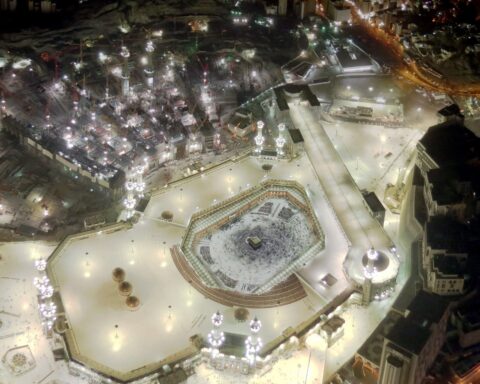 Aerial night view of Masjid al-Haram in Mecca, showing the Kaaba at the centre of the Grand Mosque surrounded by pilgrims during Hajj