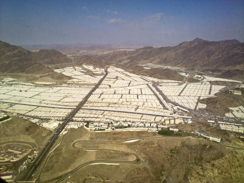 Aerial view of the Mina tent city showing the vast white fireproof tent infrastructure that accommodates millions of Hajj pilgrims during the stoning ritual, approximately three miles east of Mecca. The 2015 Mina stampede killed at least 1,470 pilgrims at this site.