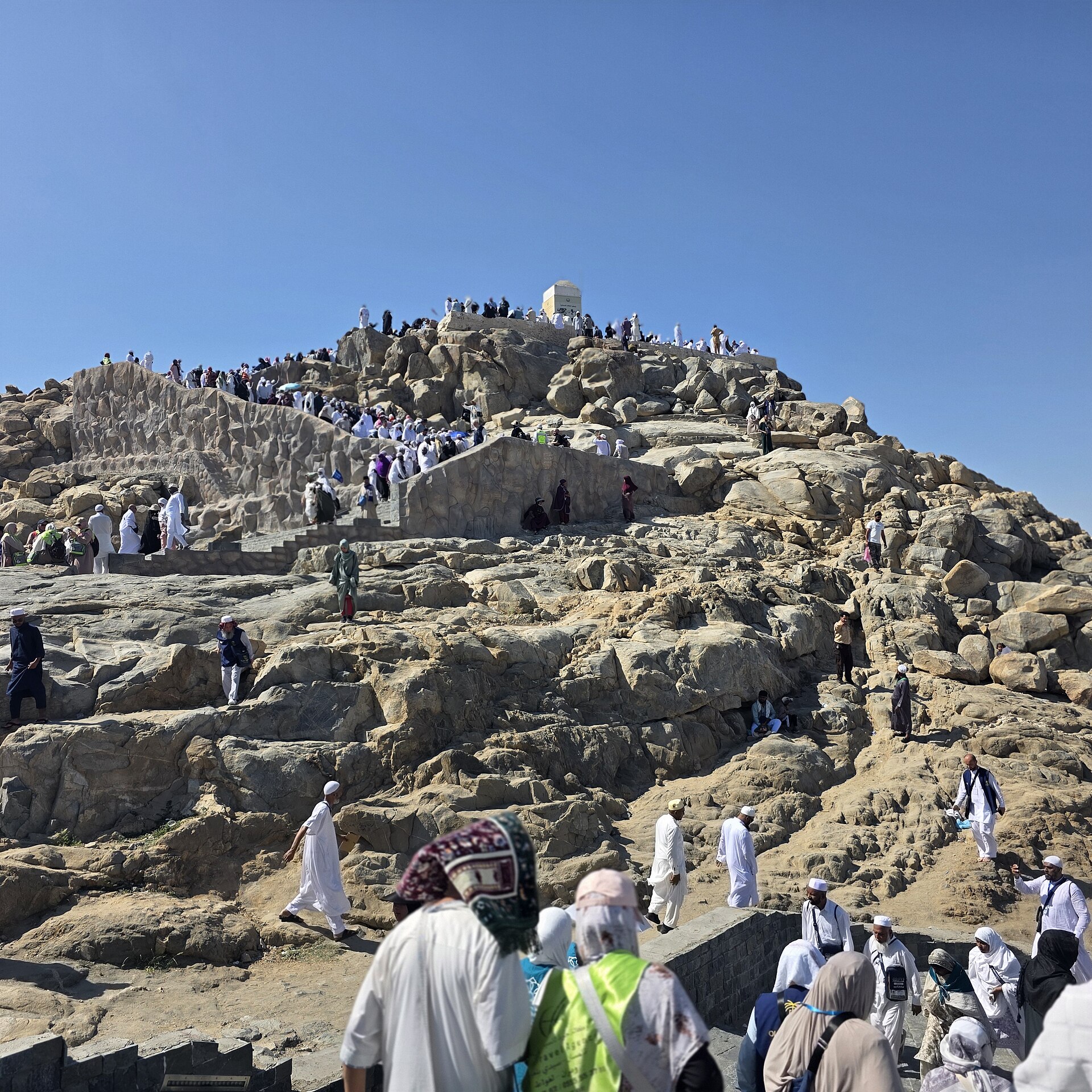 Pilgrims ascend Jabal al-Rahmah (Mount of Mercy) on the Plain of Arafah during Hajj