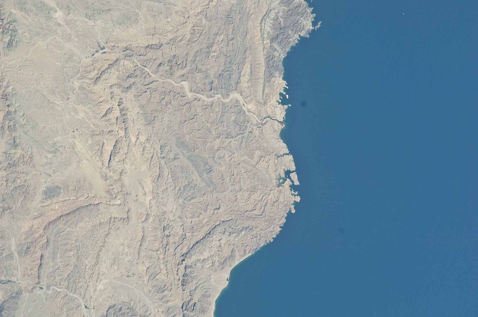 Muscat Bay coastline from NASA astronaut photography — the diplomatic quarter where four rounds of US-Iran nuclear talks have been hosted by Oman
