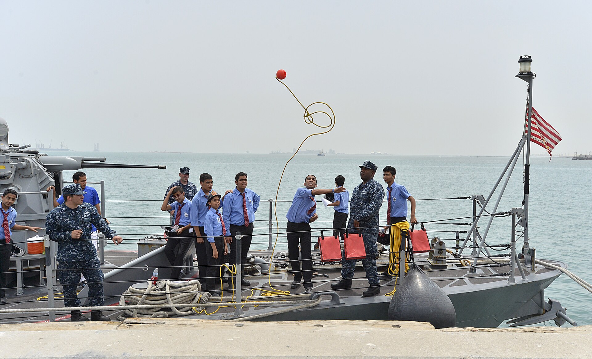 US Navy personnel aboard a patrol vessel at Naval Support Activity Bahrain in Manama — NSA Bahrain hosts 7,600 US military personnel and 78 tenant commands across 62 acres in the Bahraini capital, making it the primary target of Iranian maritime threats