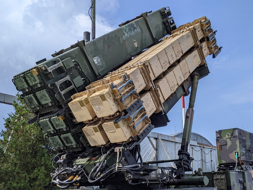 A PAC-3 Missile Segment Enhanced launcher with distinctive tan missile canisters elevated in firing position, showing the hit-to-kill interceptors whose titanium cycloid fragments contribute to post-intercept debris fields