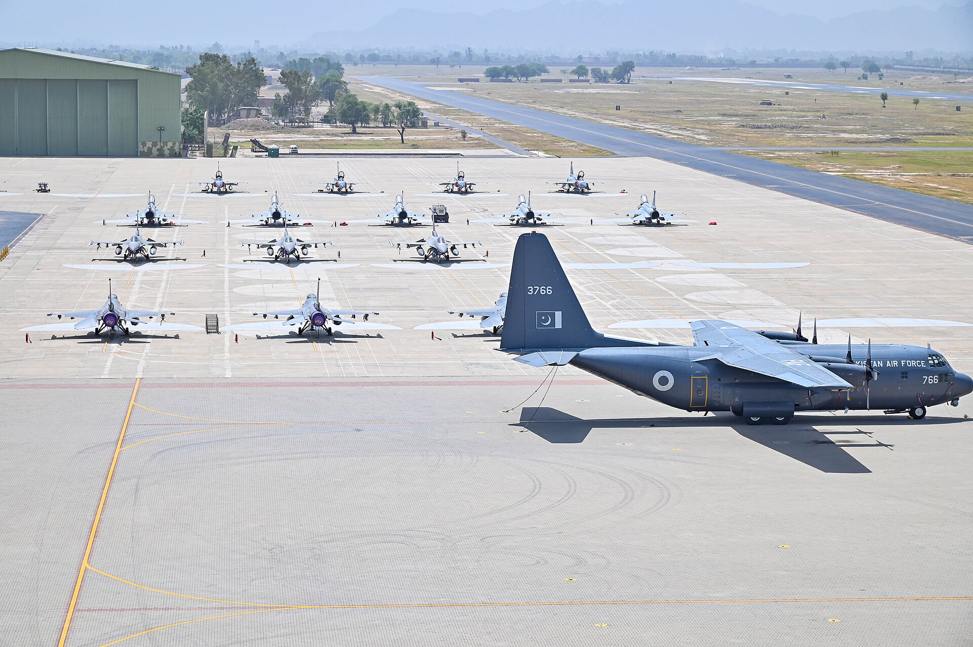 Pakistan Air Force F-16 fighters and C-130 transport parked on the flightline at a Pakistan Air Force base during Exercise Falcon Talon 2024, a joint exercise with the US Air Force — the same aircraft type that deployed non-stop from Islamabad to Saudi Arabia for Exercise Spears of Victory in January 2026