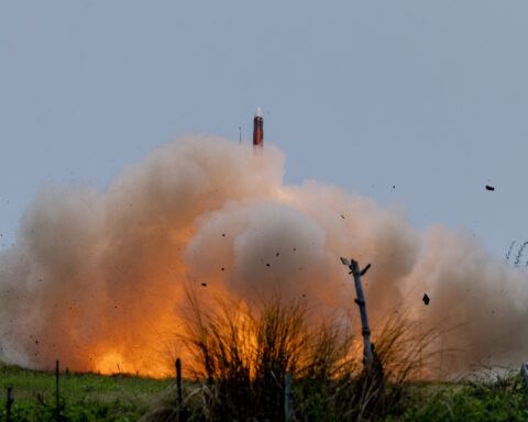 A PAC-3 MSE interceptor launches during a Patriot missile live-fire exercise, erupting in a column of fire and smoke against an overcast sky