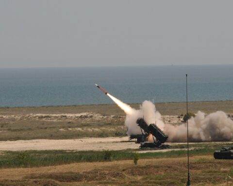 A PAC-3 Patriot missile system fires an interceptor at a live-fire range, with smoke billowing from the launcher. The UAE deploys Patriot PAC-3 batteries as part of its layered air defence against Iranian ballistic missiles and drones.