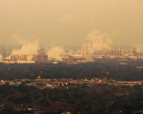 Petrochemical refineries visible from the air near Houston, Texas at dusk. Saudi Arabia generated an estimated $826 million per day in crude revenue at $114 Brent — but at 7.25 million bpd, 30 percent below February output.