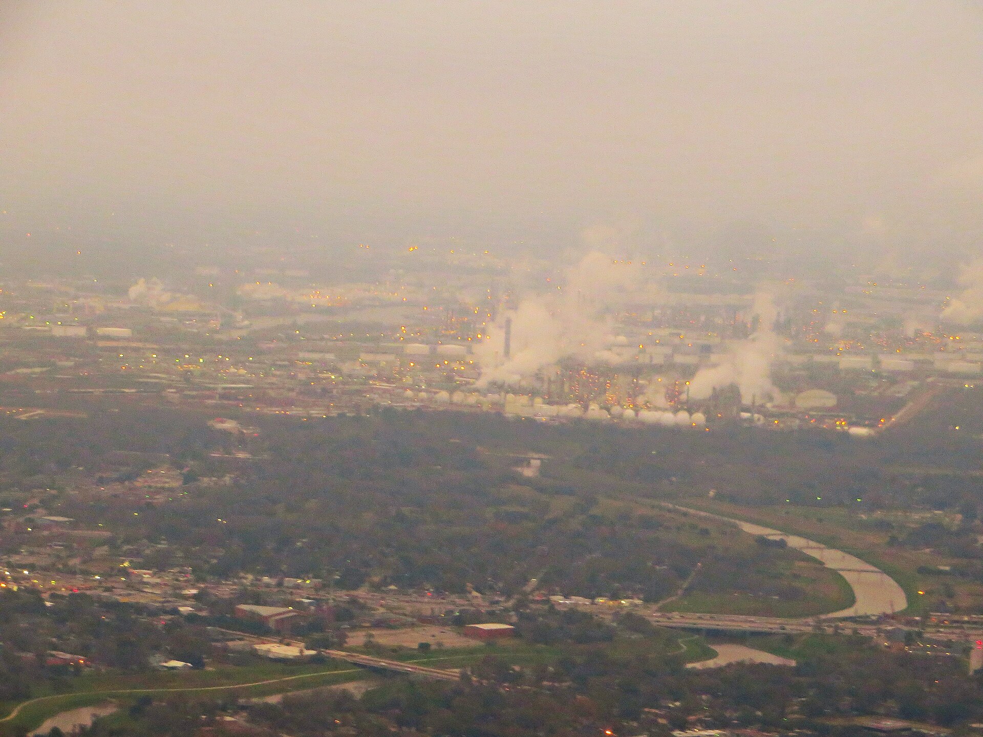 Aerial view of petrochemical refinery complex, illustrating global oil processing capacity. Saudi daily crude revenue rose from $748M to $826M as Brent climbed from $72 to $114 — but only because war damage cut output from 10.4 to 7.25 million barrels per day.