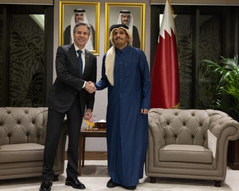 Qatar Prime Minister Sheikh Mohammed bin Abdulrahman Al Thani in diplomatic meeting, Qatar flag behind, Doha