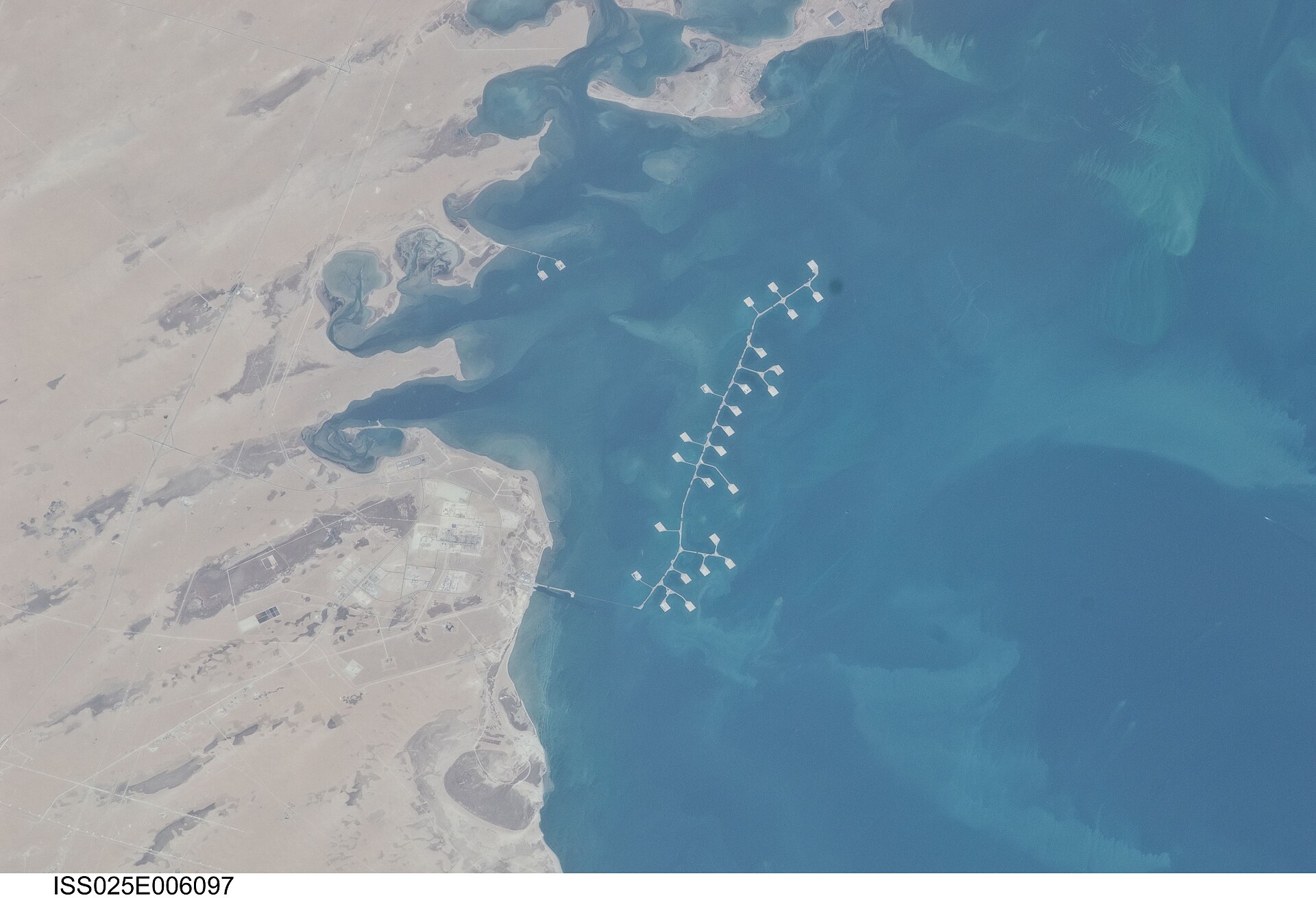 NASA ISS satellite view of Ras Tanura, Saudi Arabia, showing offshore oil loading berths extending into the Persian Gulf.