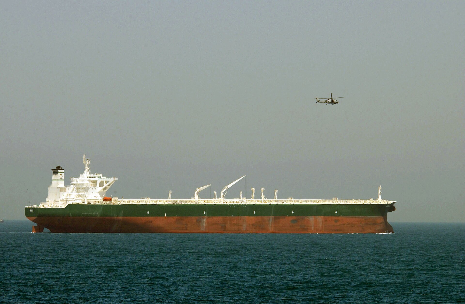Saudi Aramco crude oil tanker AbQaiq under US Navy helicopter escort in the Persian Gulf, June 2003, illustrating Saudi Arabia oil export dependency on protected sea lanes