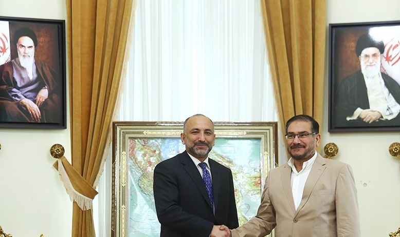 Ali Shamkhani at an official government meeting in Tehran, 2022, with portraits of Khomeini and Khamenei on the wall behind him