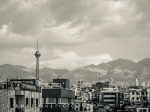 Tehran skyline at dusk with Milad Tower rising above the city, Alborz Mountains in the background
