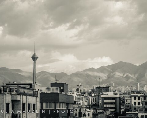 Tehran skyline at dusk with Milad Tower rising above the city, Alborz Mountains in the background