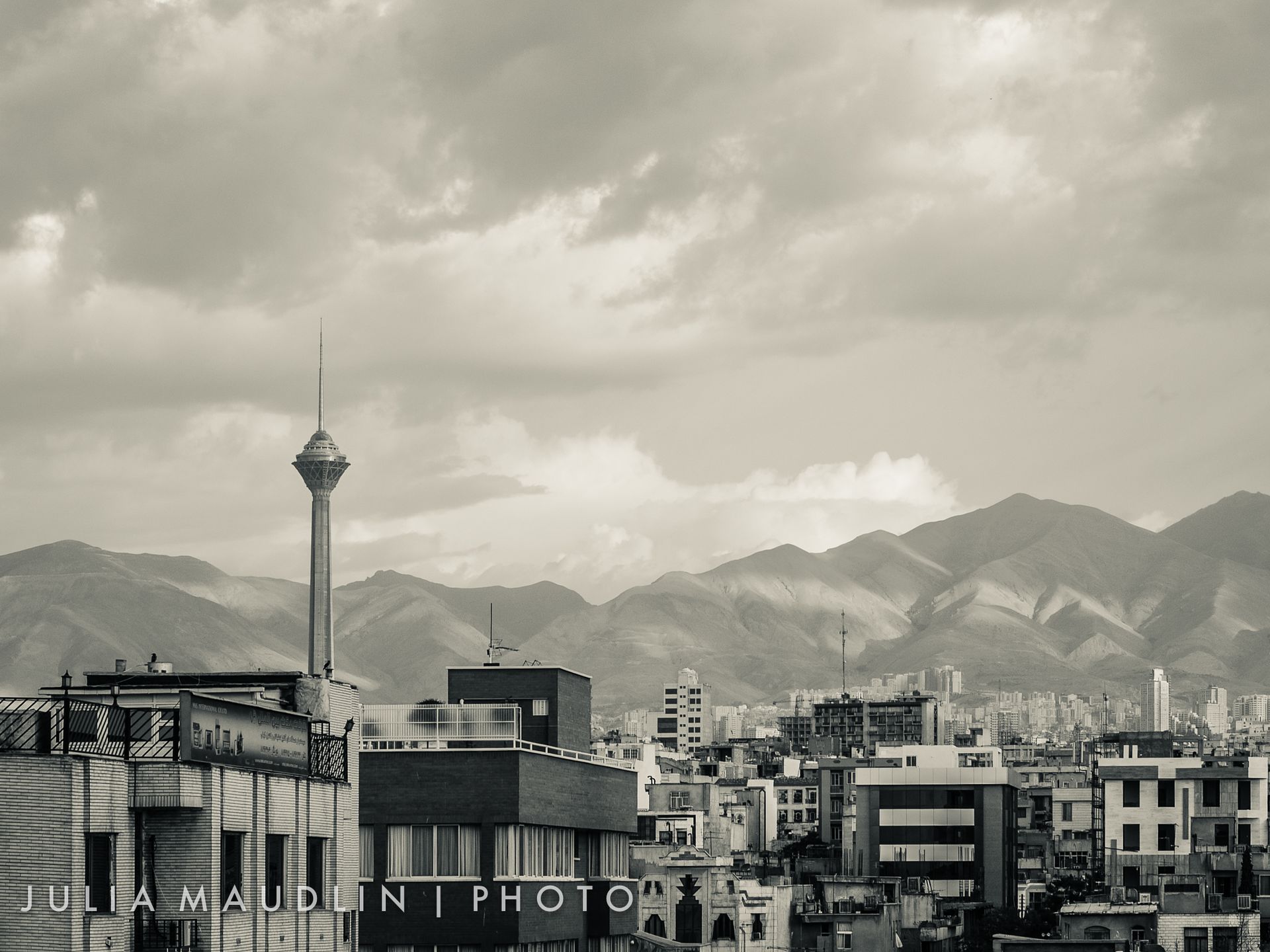 Tehran skyline at dusk with Milad Tower rising above the city, Alborz Mountains in the background