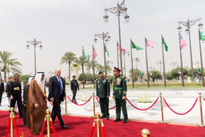 President Trump walks with King Salman bin Abdulaziz Al Saud of Saudi Arabia during state visit welcoming ceremony, Riyadh, May 2017. American and Saudi flags line the red carpet.