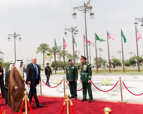 President Trump walks with King Salman bin Abdulaziz Al Saud of Saudi Arabia during state visit welcoming ceremony, Riyadh, May 2017. American and Saudi flags line the red carpet.